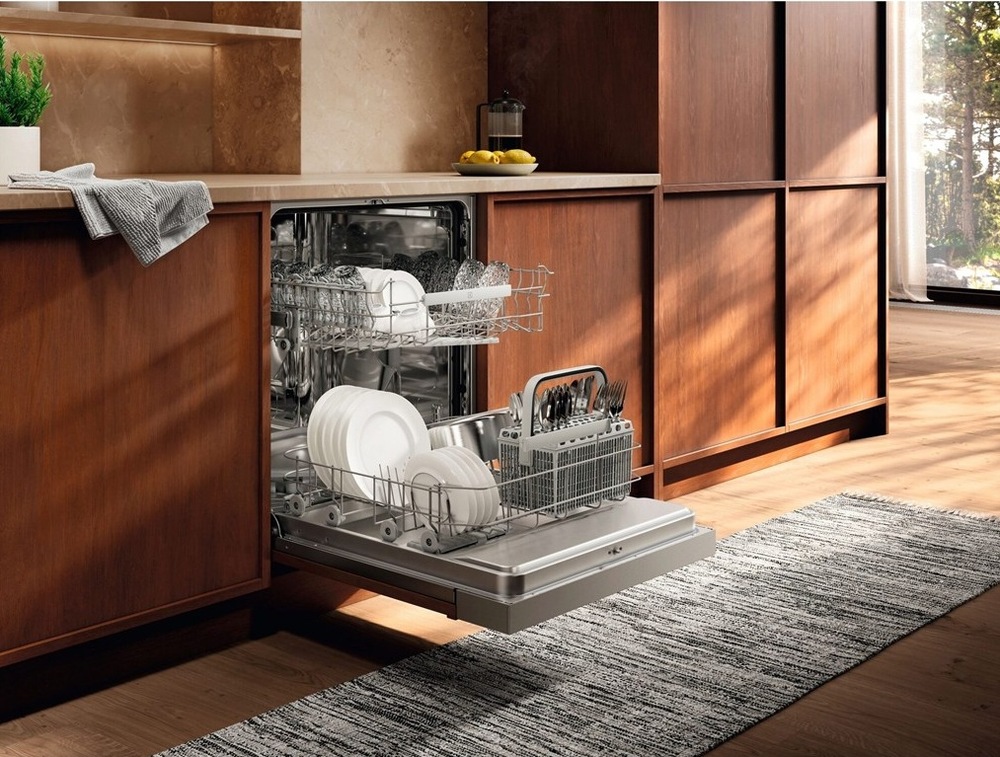 Otevřená myčka Electrolux E52ID100SX série 500 plná nádobí v kuchyni s dřevěným dekorem.