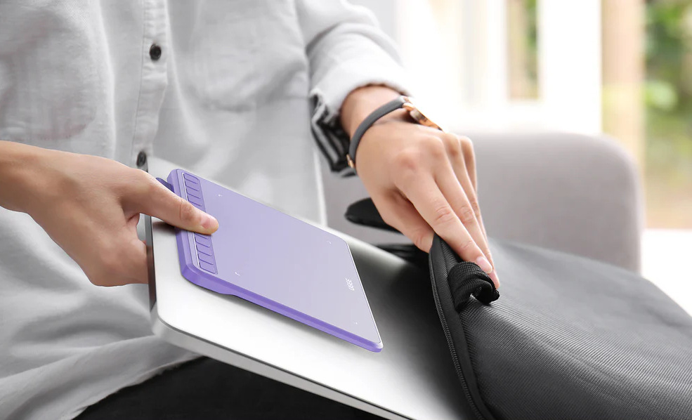 Muž vkládá laptop a tablet UGEE S640 do batohu