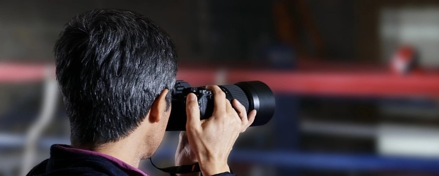 Pohled šikmo ze strany na muže fotografujícího pomocí Sony Alpha 7 III