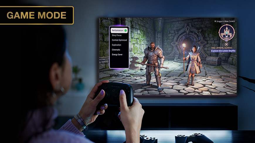 Televize Hyundai HL 327602V Herní režim Game Mode na televizoru: Hráčka s ovladačem v rukou hrající RPG videoherní titul s herním menu na obrazovce. Štítek: GAME MODE