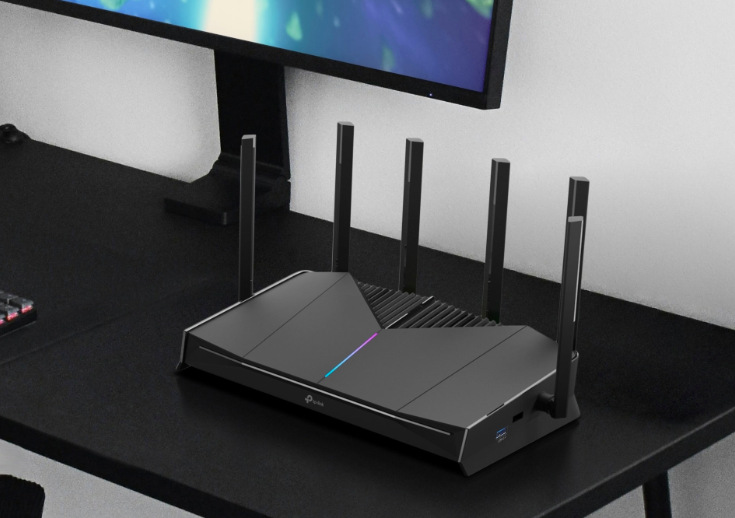 Router TP-Link Archer GE400 Gaming černý Herní Wi-Fi router TP-Link Archer GE400 Gaming umístěný na stole v moderním herním pracovním prostoru