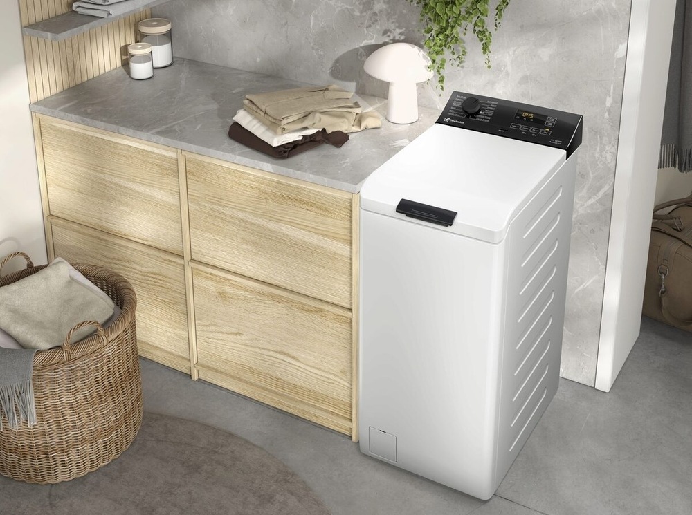 Pračka Electrolux SensiCare 600 EW6T836C bílá Vrchem plněná pračka Electrolux EW6T836C řady SensiCare 600 vedle linky s hlubokými zásuvkami.