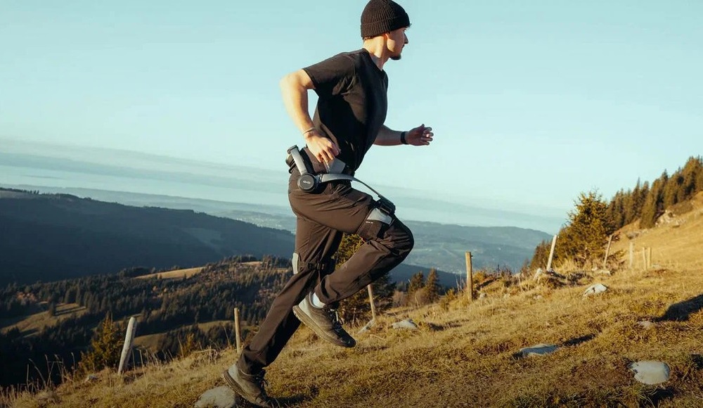 Exoskeleton Hypershell Pro S černý Muž běží do kopce v horském terénu a má nasazený exoskeleton Hypershell Pro S.