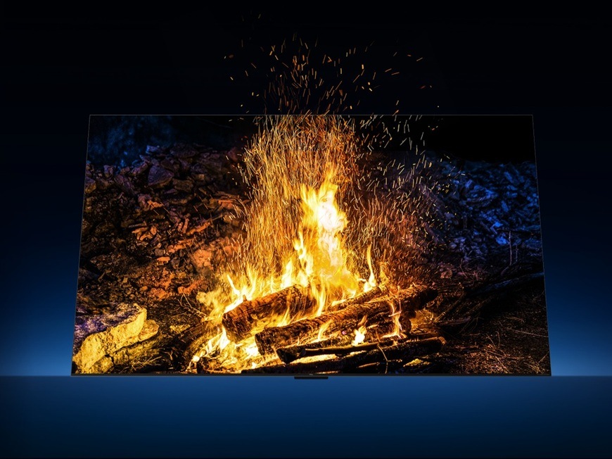 Televize TCL 65C7L zobrazuje realistickou scénu hořícího ohně s jiskrami, ukázka vysokého kontrastu, detailů a věrného podání barev.