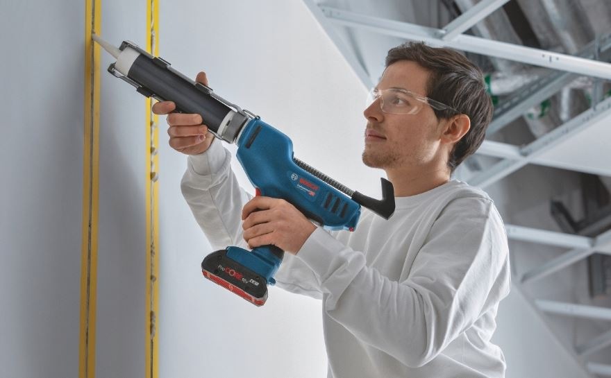 Lis Bosch Professional GCG 18V-310 (bez baterie) Muž opravuje praskliny ve zdi pomocí vytlačovací pistole Bosch Professional GCG 18V-310