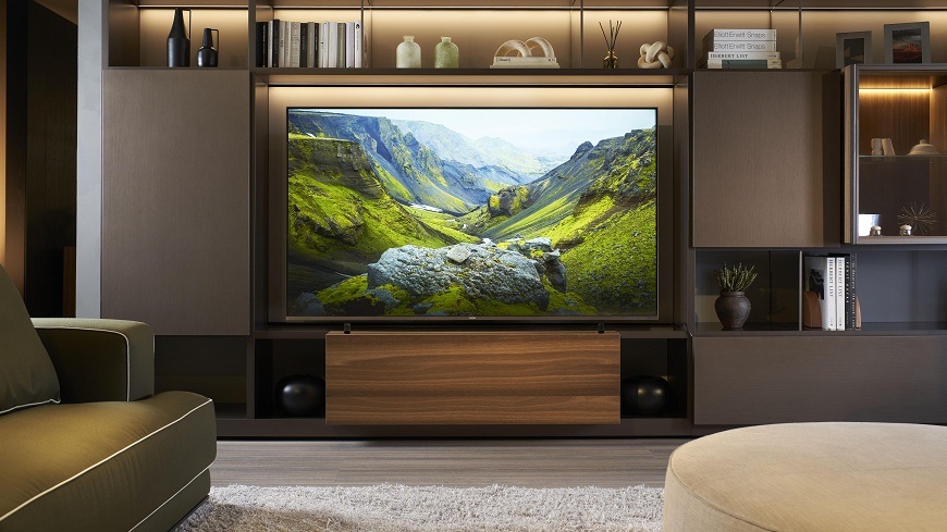 Televize Haier H75M92FUX v obýváku s obrazem přírodní krajiny