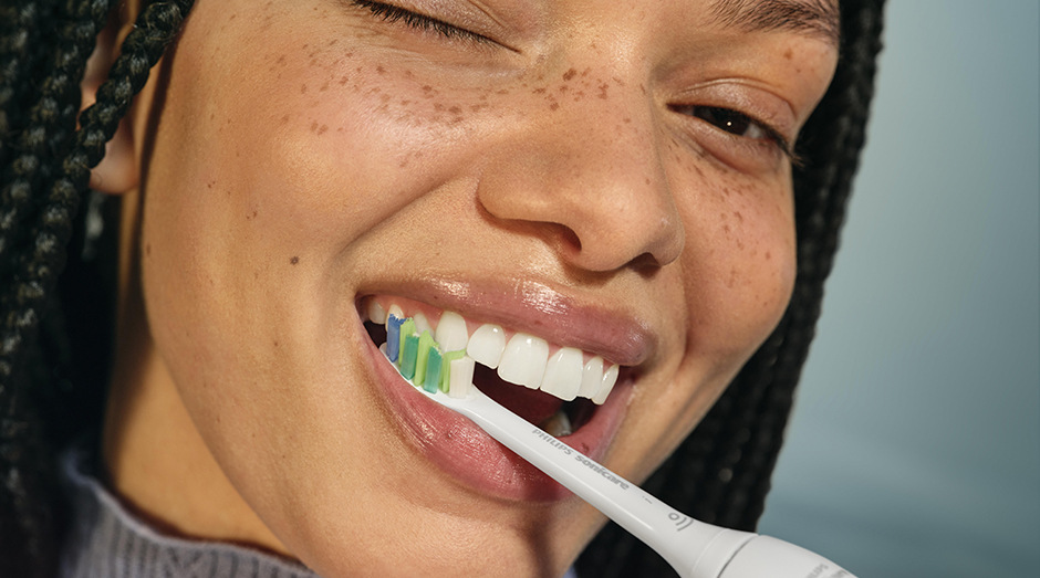 Náhradní hlavice Philips Sonicare InterCare HX9004/87, 4 ks bílá Žena si čistí zuby kartáčkem Philips Sonicare