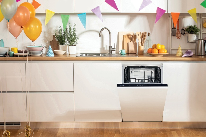 Vestavná myčka nádobí Gorenje GV520E15 se nachází v moderní kuchyni, kde právě probíhá oslava.