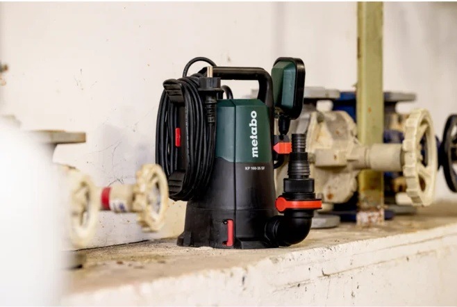 Ponorné čerpadlo Metabo KP 160-35 SF Ponorné čerpadlo Metabo v černo-zeleném provedení umístěné na podlaze technické místnosti vedle potrubí a ventilů