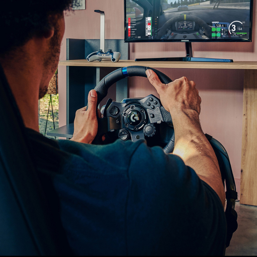 Hráč používající Logitech G923 Racing Wheel and Pedals při závodní hře na monitoru