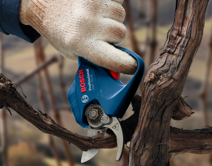 Bosch Professional GGP 12V-25 při stříhání silnější větve v ruce s rukavicí