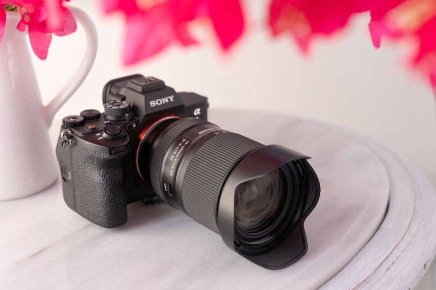 Objektiv Tamron 25-200 mm f/2.8-5.6 Di III VXD G2 (Sony FE) černý Pohled zepředu na fotoaparát Sony a objektiv Tamron 25–200 mm f/2.8–5.6 Di III VXD G2 se sluneční clonou