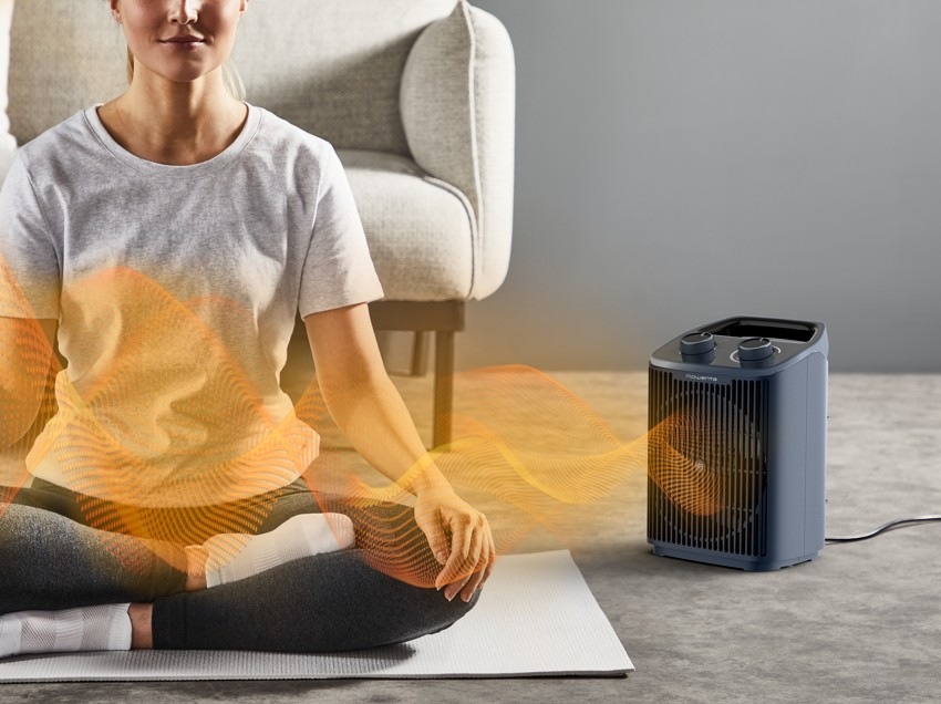Teplovzdušný ventilátor Rowenta SO2351F0 Intense Comfort šedý Žena medituje na zemi a vedle ní je teplovzdušný ventilátor Rowenta SO2351F0 Intense Comfort