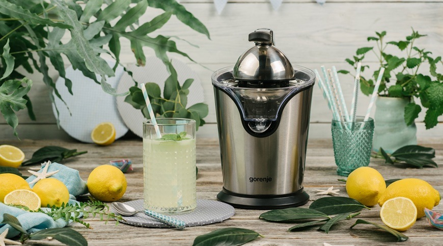 Lis na citrusy Gorenje CJ100HE nerez Lis na citrusy Gorenje CJ100HE v nerezovém provedení je položený na kuchyňské lince. Kolem něj jsou položeny citrony a jedna sklenička s citronovou šťávou.