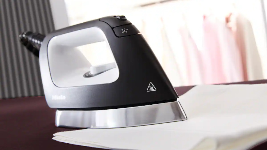 Žehlicí systém Miele B4847 FashionMaster 4.0 Žehlička položená na přeložené utěrce