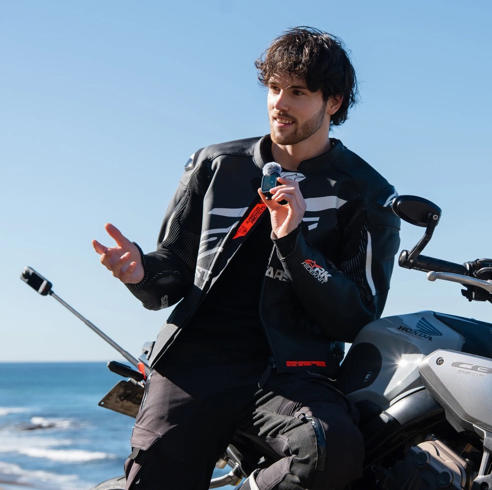 Dálkový ovladač Insta360 GPS/MIC černý Motorkář sedí na motocyklu a mluví do mikrofonu na dálkovém ovladači Insta360 GPS/MIC
