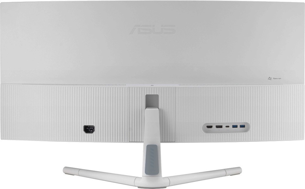 Na obrázku je zadní strana monitoru Asus VU34WCIP-W 34" v bílém provedení. Dobře je vidět široké prohnuté tělo displeje, světlý zadní kryt a spodní část s jemným svislým žebrováním. Uprostřed je uchycení bílého stojanu se třemi nohami. Na zadní straně jsou vidět konektory, včetně napájecího vstupu vlevo a panelu s porty vpravo. V pravé horní části zadního krytu je označení Nano-Ion.