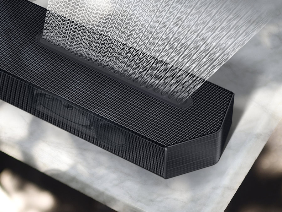 Detail soundbaru Samsung HW-Q600C, z nějž vycházejí řady malých bílých kroužků znázorňující zvuk