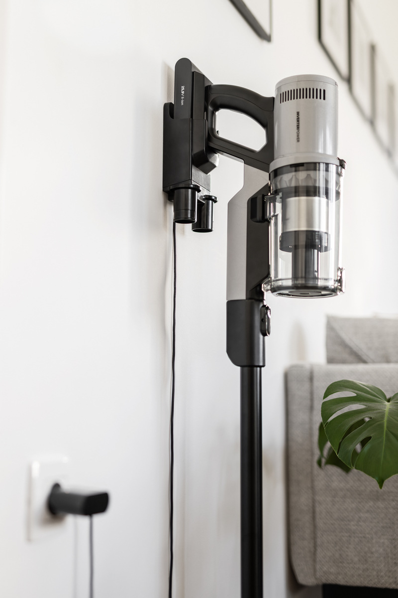 Tyčový vysavač Gorenje SVC259400NES NEO ESSENTIAL INVERTERPOWER stříbrný vysavač gorenje visí na držáku na stěně