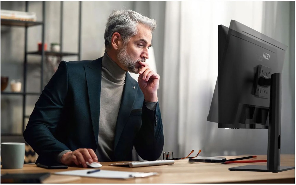 Monitor MSI PRO MP273UP E6 černý Muž pracující s monitorem MSI PRO MP273UP E6 v kanceláři