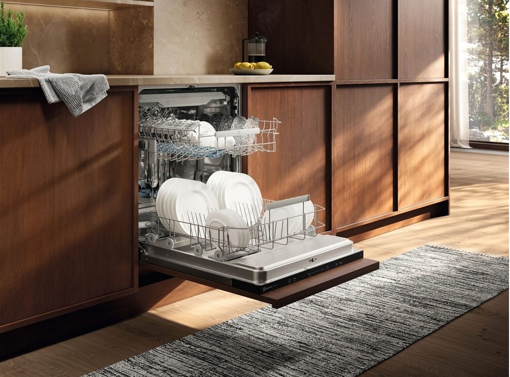 Otevřená myčka Electrolux E62LC200T série 600 plná nádobí v kuchyni s dřevěným dekorem.