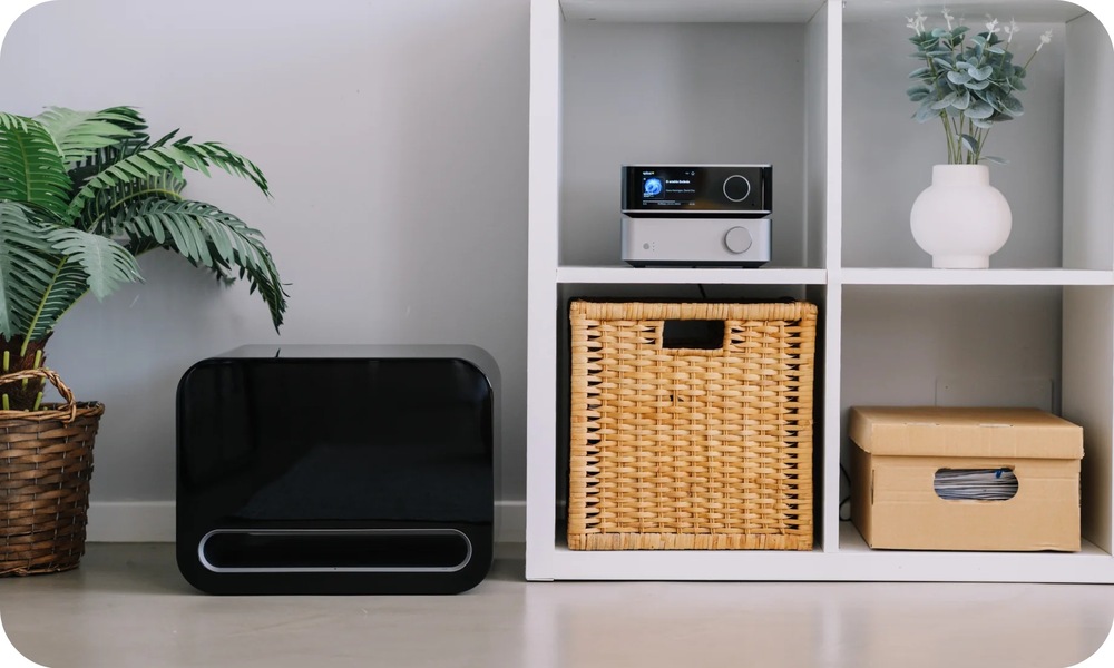 Subwoofer WiiM Sub Pro bílý Subwoofer WiiM Sub Pro umístěný vedle televizní sestavy v moderním obývacím pokoji