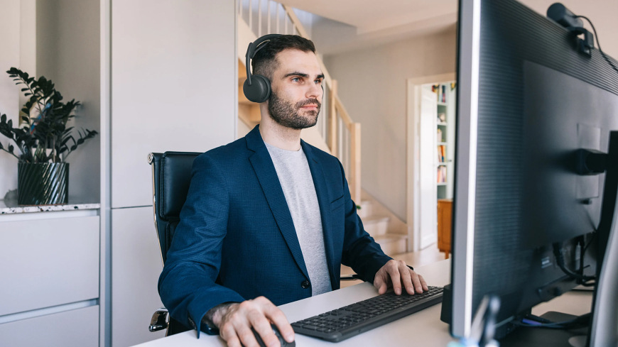 Muž pracující u počítače s headsetem Logitech Zone Wireless 2 ES v domácí kanceláři