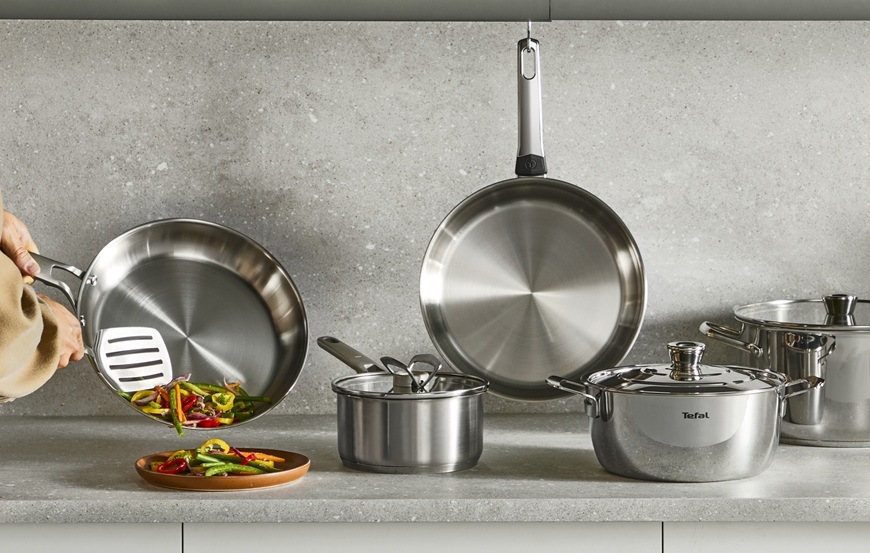 Pánev Tefal Extreme G7620404, 24 cm nerez Sada nádobí položená na kuchyňské lince.