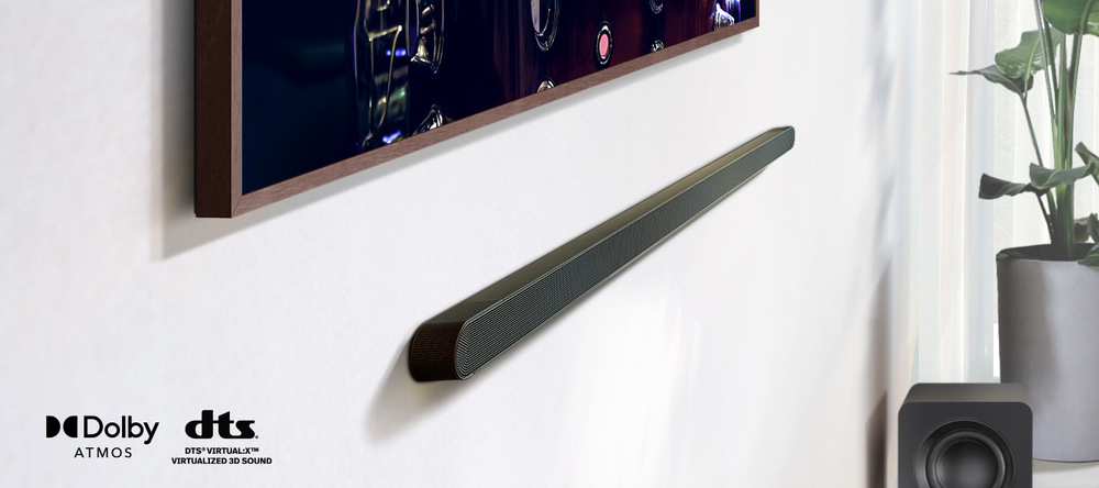 Soundbar Samsung HW-S800D je připevněný na zdi pod TV Samsung Frame,v  levém dolním rohu jsou loga Dolby Atmos a dts