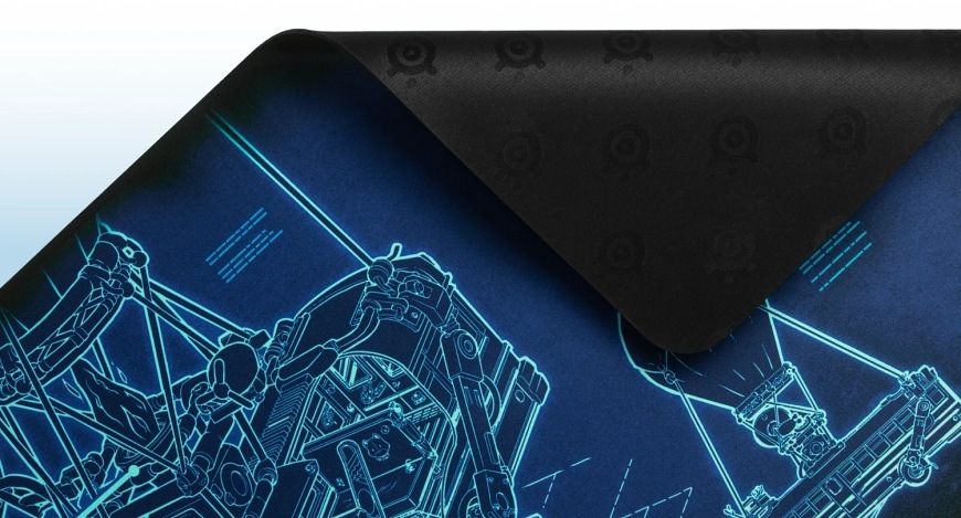 Podložka pod klávesnici a myš SteelSeries QcK XXL Fortnite modrá Detail podložky QcK Battle Bus s odklopeným rohem odhalujícím gumovou spodní stranu
