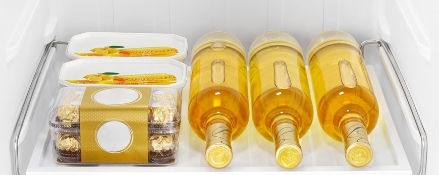 Americká lednice Hisense RS3P558NEID nerez Na univerzální polici Multi Try jsou položeny 3 skleněné láhve, 2 plastové krabičky s jídlem a jedna krabička s čokoládou.