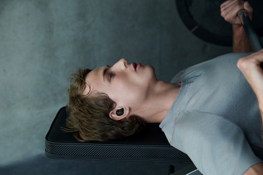 Sluchátka Sony Noise Cancelling WF-1000XM6 stříbrná Muž zdvihající činky má nasazená komfortní sluchátka Sony WF-1000XM6