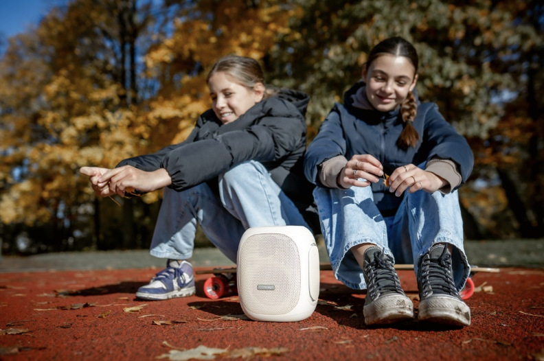 Dvě dívky poslouchají přenosný reproduktor Concept SoundJoy BR5036 během venkovního posezení
