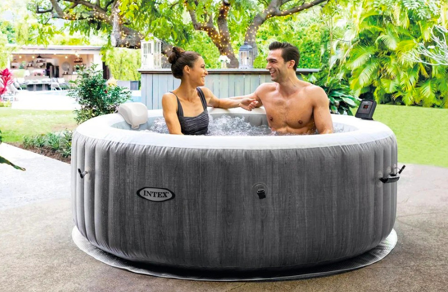 Pár relaxuje ve vířivce Intex PureSPA Greywood Deluxe™ na zahradní terase