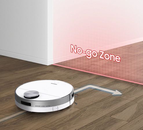 Robotický vysavač Samsung Jet Bot+ Robotický vysavač Samsung Jet Bot+ na podlaze, šipka ukazuje směr pohybu zabočující doprava, před vysavačem je červeně vyzančená zóna No-go Zone vynechaná z úklidu