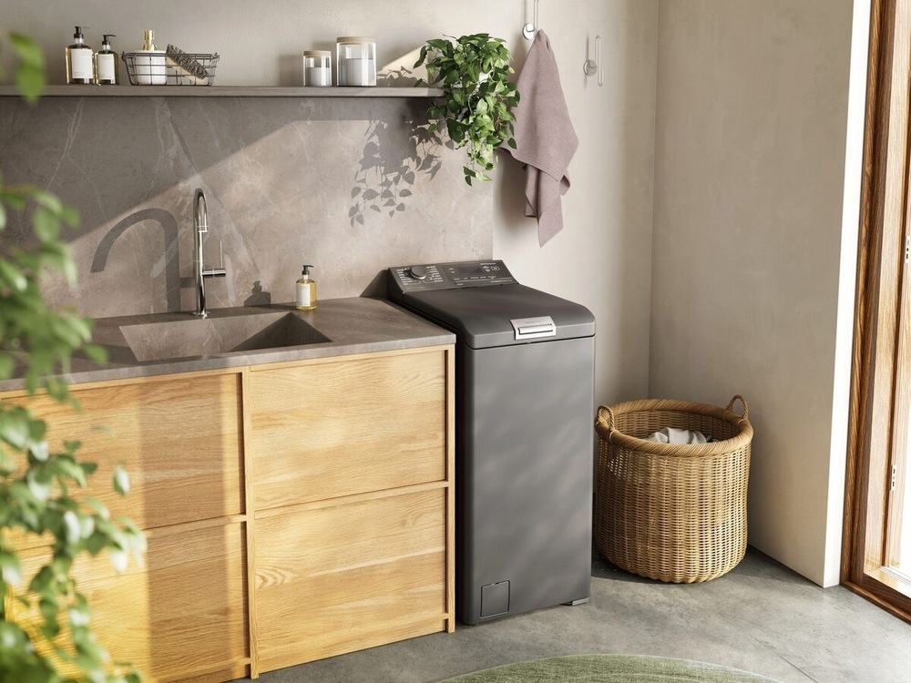 Pračka Electrolux SteamCare® 700 EW7T337DC stříbrná Vrchem plněná pračka Electrolux EW7T337DC řady 700 SteamCare vedle linky s dřezem.