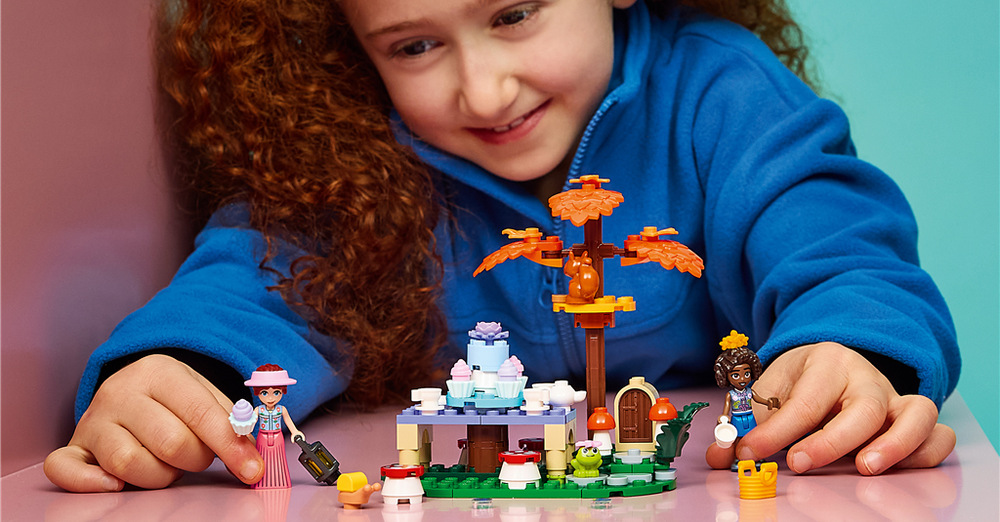 Stavebnice LEGO® Friends 42690 Lesní čajový dýchánek Aliya a Paisley chystají lesní čajový dýchánek s dortem, cupcaky a nádobím na stole mezi stromy.