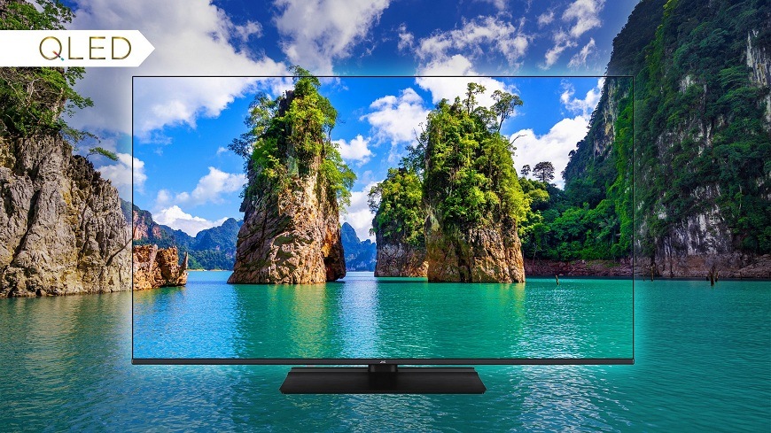 Televize JVC LT-65VDQ9435 QLED televize JVC zobrazující živý obraz tropické krajiny s tyrkysovým mořem a skalními ostrůvky