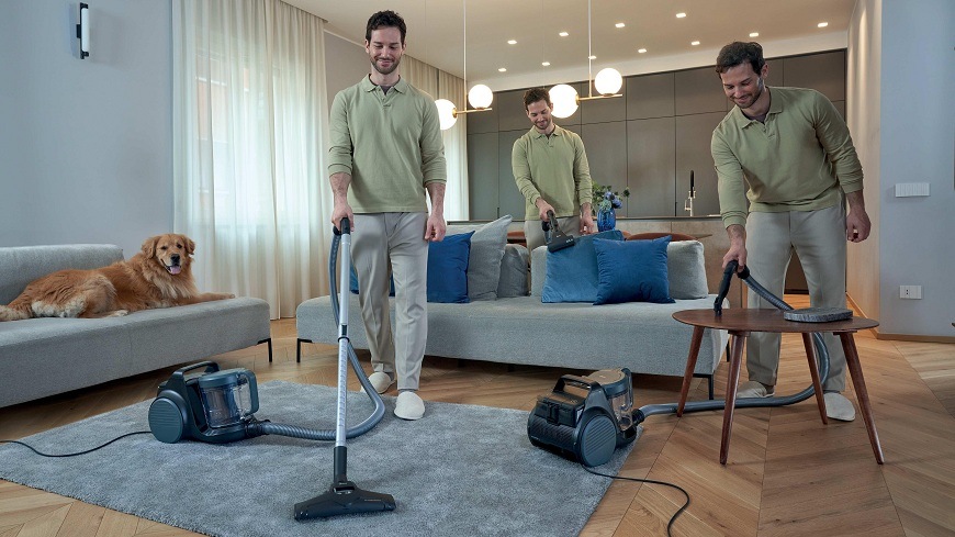 Podlahový vysavač Hoover HP210P 011 černý/šedý muž používá vysavač Hoover HP210P 011 na různých místech v obýváku