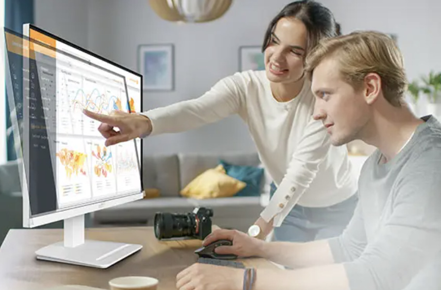 Dva lidé společně pracují u monitoru MSI PRO MP273W E14A a prohlížejí grafy na obrazovce