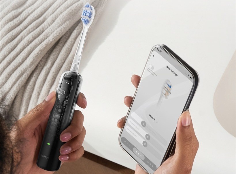 Zubní kartáček Laifen Wave Pro LFTB02-PT ABS Transparent Black průhledný Ruka drží zubní kartáček Laifen Wave Pro vedle telefonu s nastavením režimů v aplikaci.