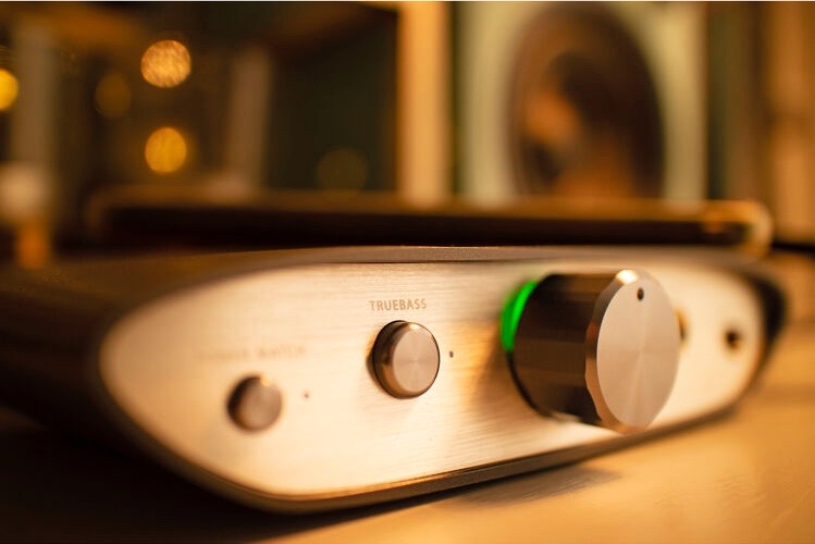 Sluchátkový zesilovač iFi audio ZEN DAC V2 černý/stříbrný Detail zapnutého iFi ZEN DAC V2 s podsvíceným ovladačem hlasitosti a tlačítkem TrueBass.