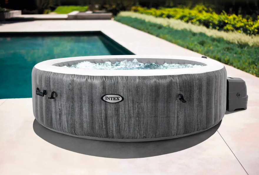 Kruhová vířivka Intex PureSPA Greywood Deluxe™ umístěná u venkovního bazénu