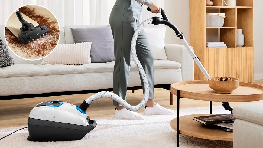 Podlahový vysavač Bosch ProSilence BGL8SIL1L bílý Žena vysávající s vysavače Bosch BGL8SIL1L světlý koberec před světlou sedačkou