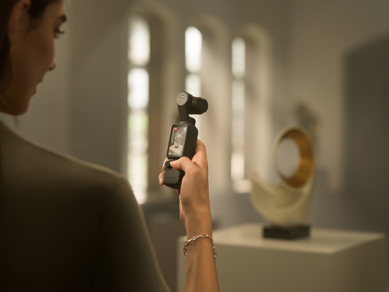 Outdoorová kamera DJI Osmo Pocket 4 Standard Combo černá Žena držící kameru v interiéru.
