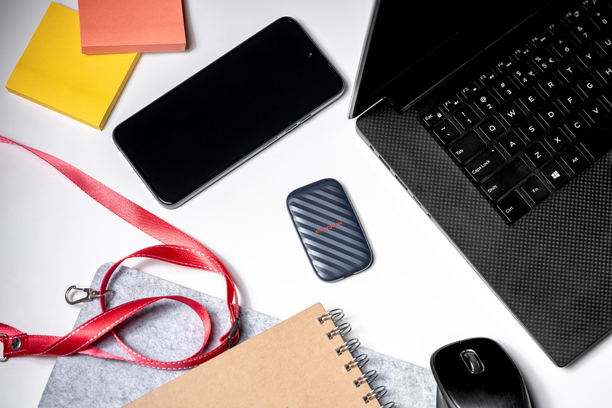 Externí SSD na pracovním stole vedle notebooku a telefonu