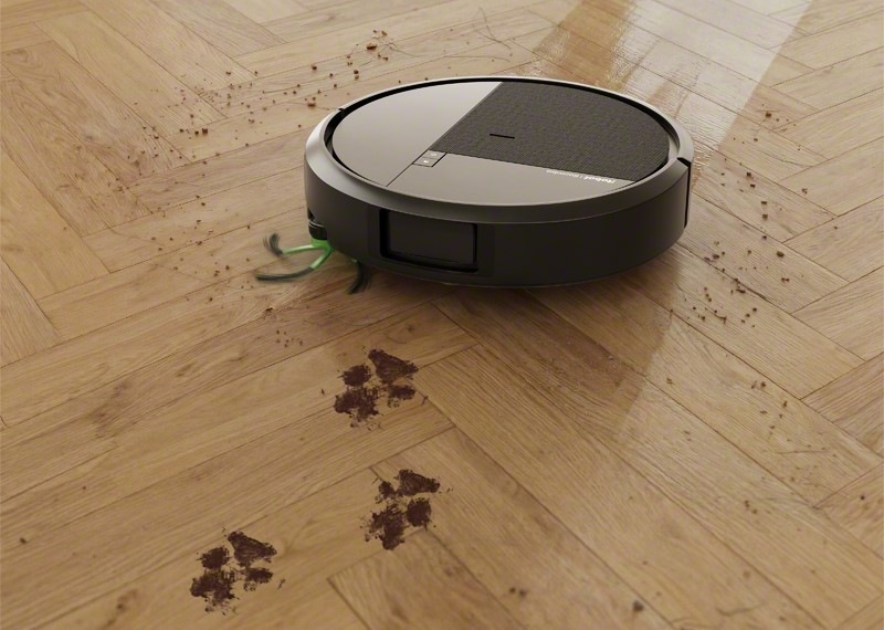 Robotický vysavač iRobot Roomba Plus 415 Combo + AutoWash dock černý Robotický vysavač iRobot Roomba Plus 415 Combo na dřevěné podlaze mopuje zaschlé packy od pejska.