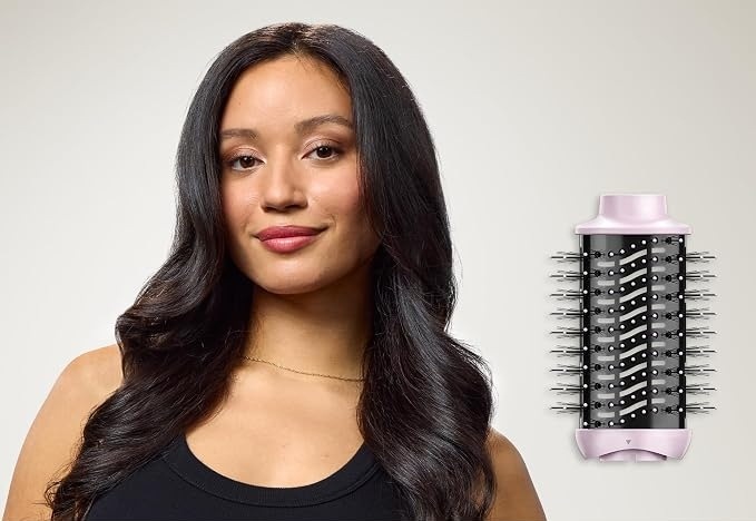 Styler Revlon One-Step RVDR5376E Pink Titanium 5v1 růžová Žena s dlouhými tmavými vlasy upravenými do výrazných lesklých vln, vedle ní je samostatně zobrazený široký kartáčový nástavec pro kulmofén Revlon