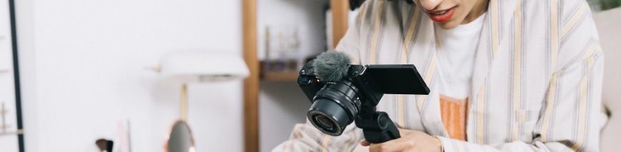 Žena pořizující video pomocí vlogovací kamery Sony ZV-E10