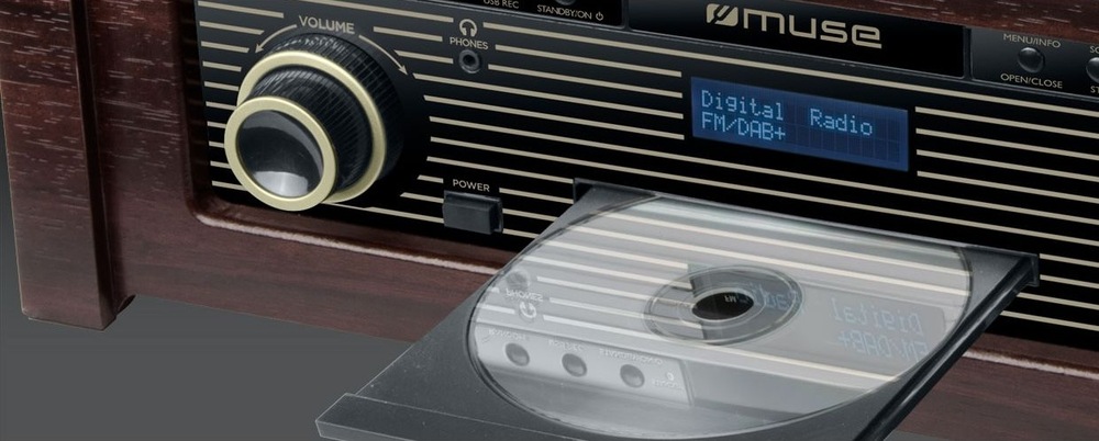 Gramofon MUSE MT-115DAB Retro gramofon Muse MT-115 DAB s vinylovou deskou na šedém stole v moderním obývacím pokoji